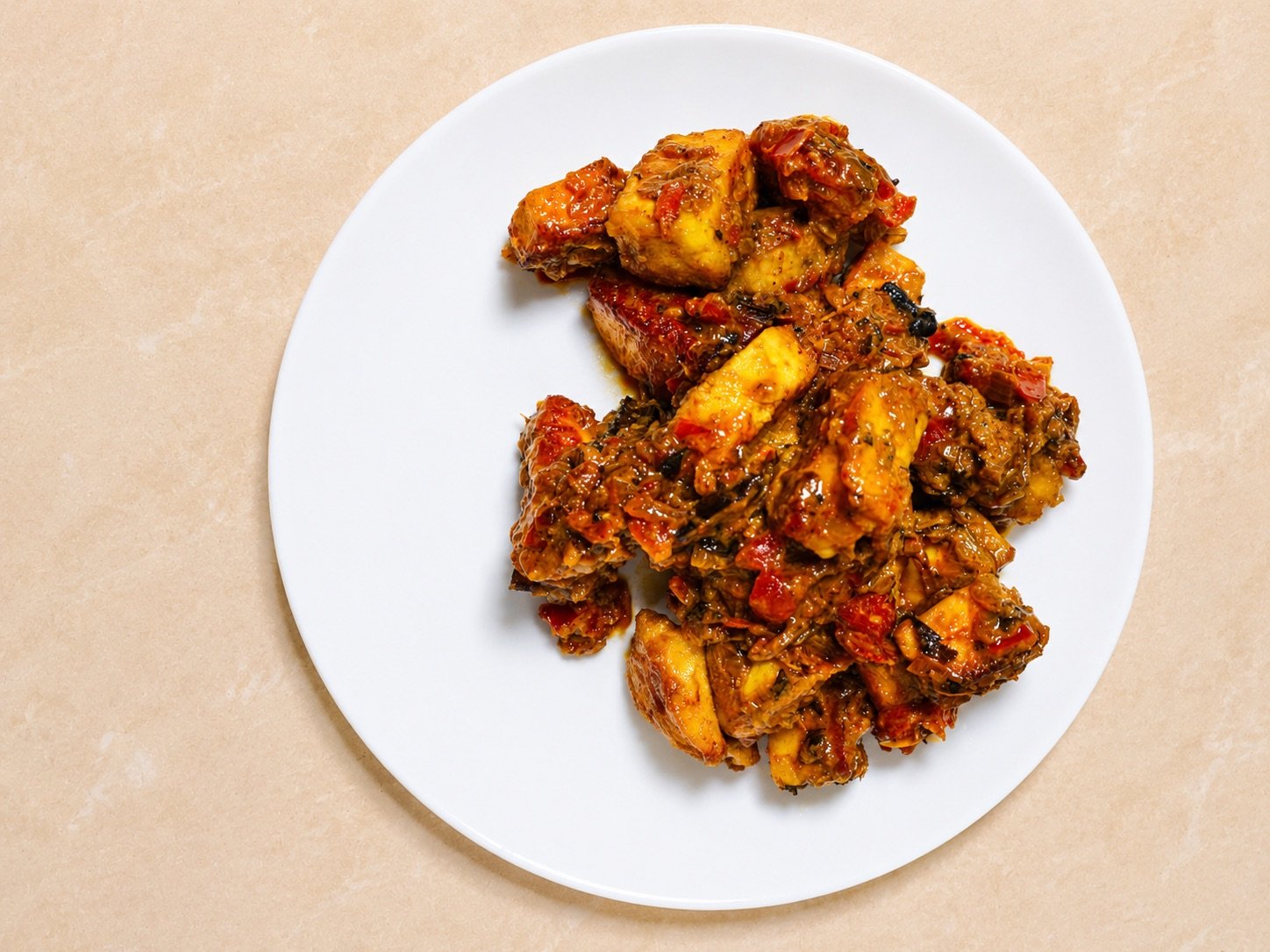 Masala paneer piled on a white plate, viewed from above