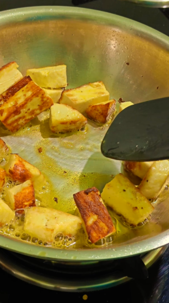 Paneer cubes frying until golden brown around the edges