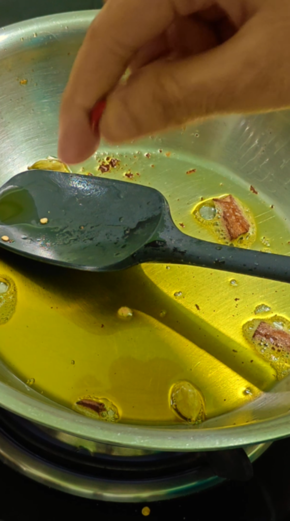 Whole spices sizzling in oil in a metal pan