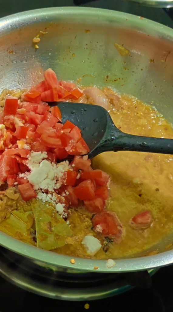 Chopped tomatoes and salt added to the sautéed onion mixture