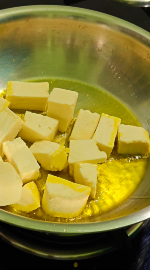 Paneer cubes added to hot oil in a metal pan