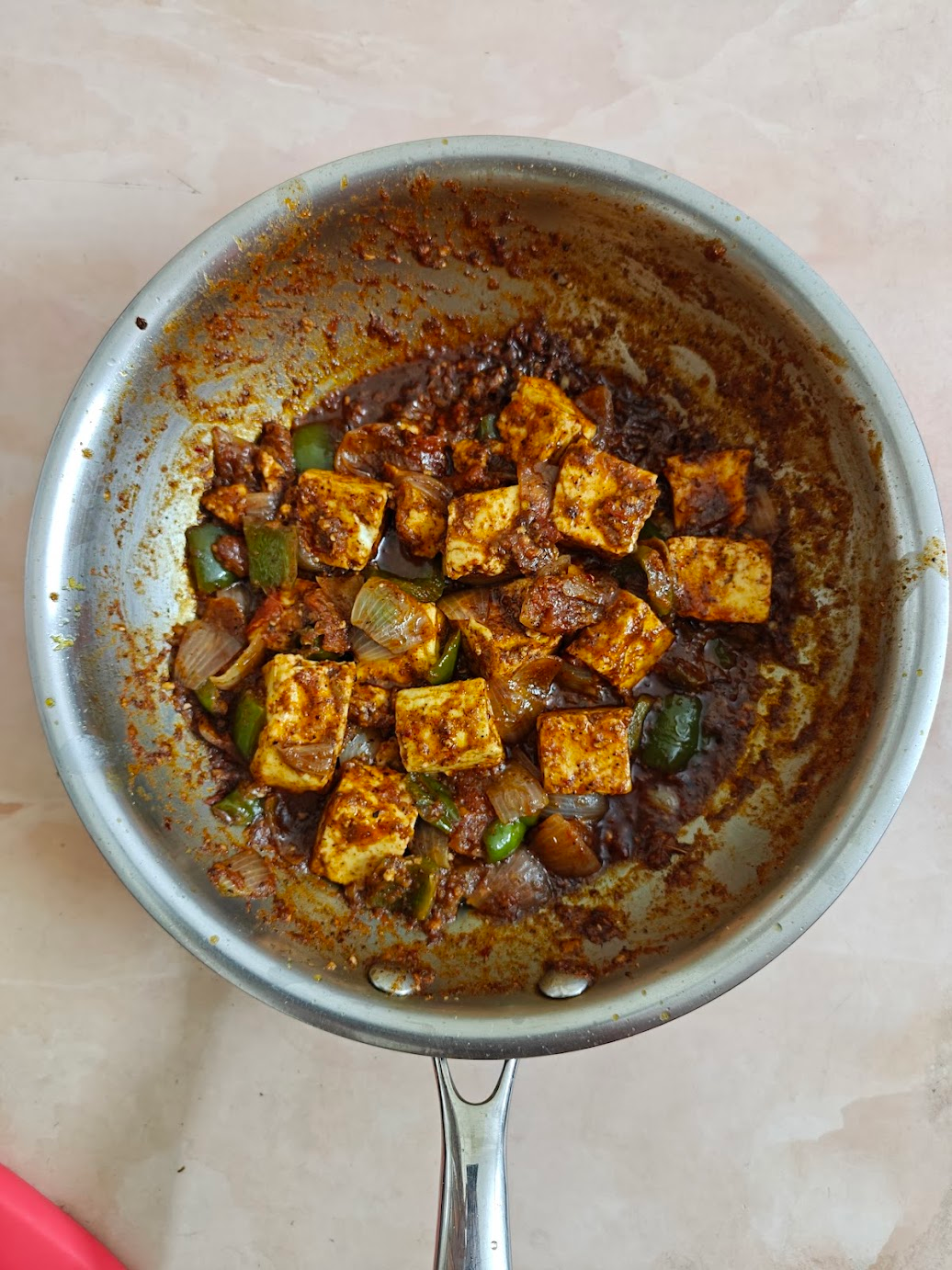 Finished semi-dry Kadai Paneer in a pan with paneer, onions and bell peppers