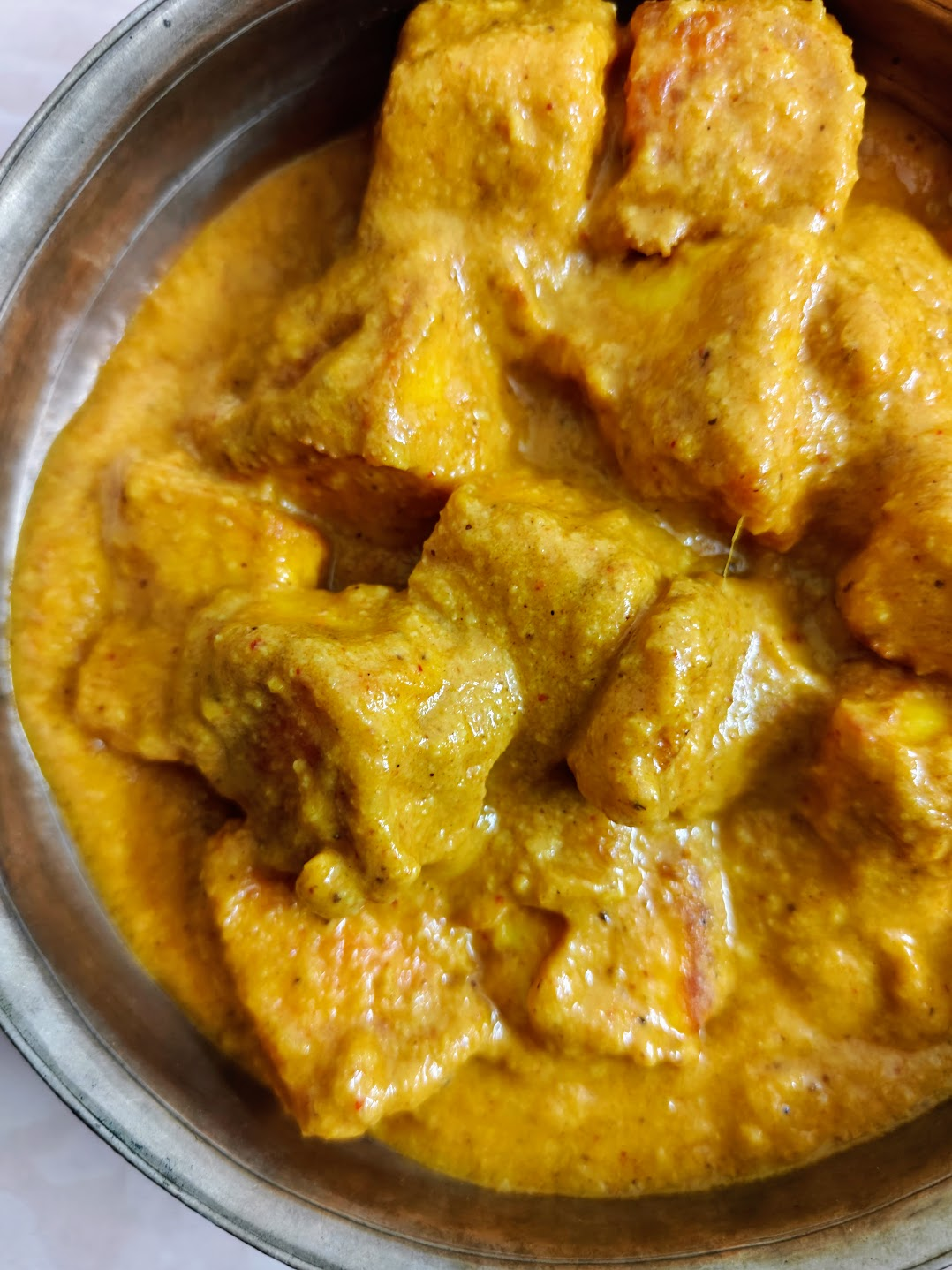 Butter paneer with paneer cubes coated in a rich, creamy orange tomato-cashew gravy.
