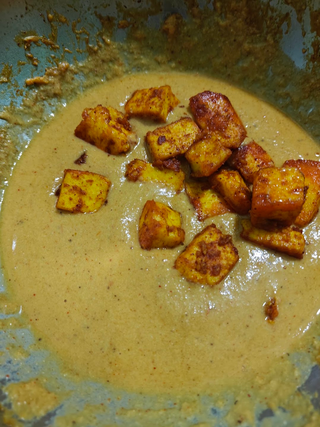Finished paneer butter masala with paneer cubes in a creamy orange tomato-cashew gravy.